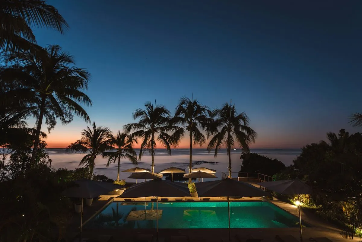 Solnedgang over hotellområde og svømmebasseng