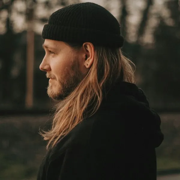 Portrett i mørk jakke og lue